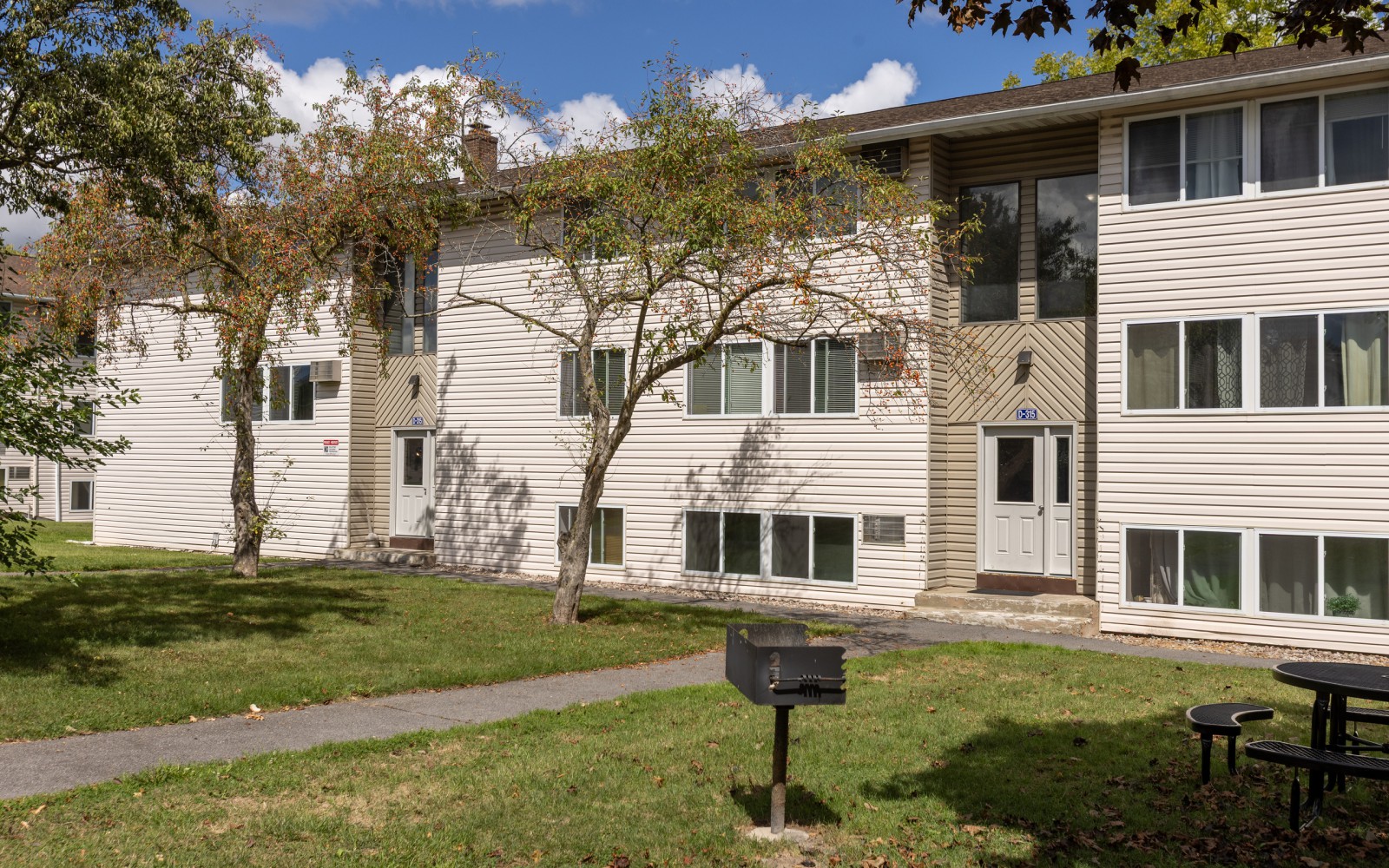 Apartment building, lawn, grill and picnic table at Brook Manor Apartments, Syracuse NY