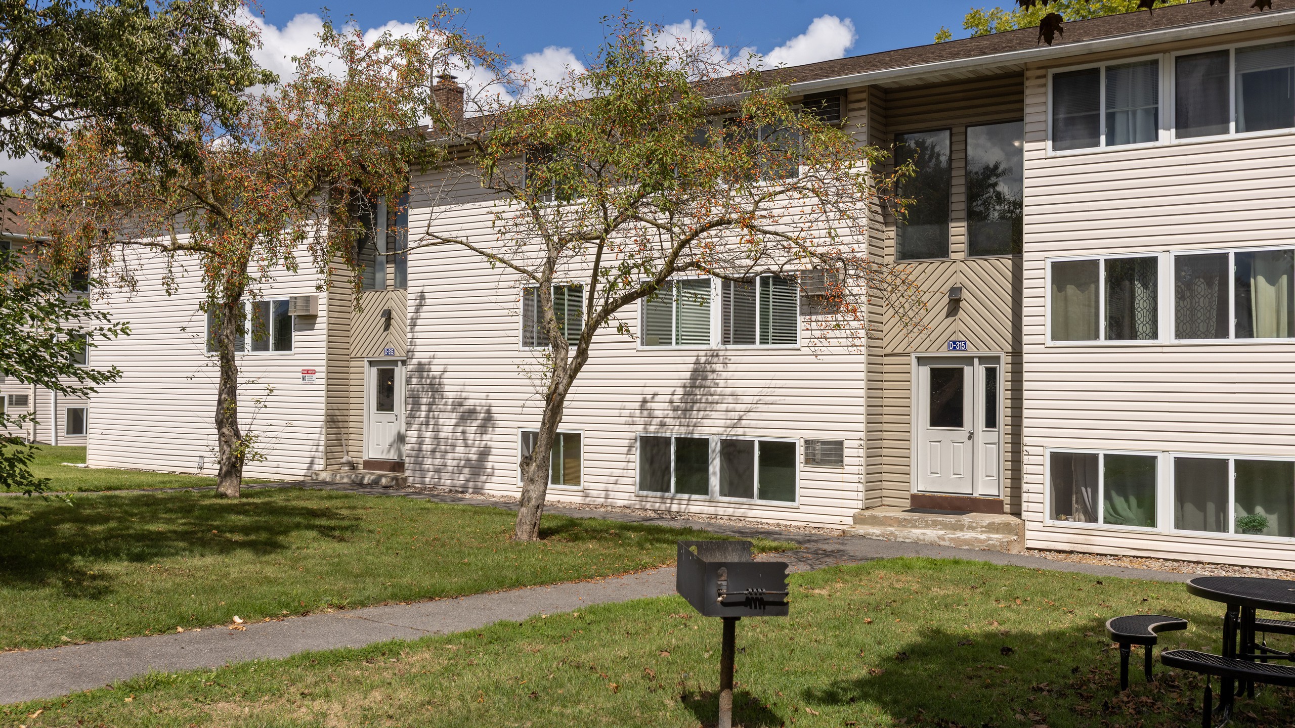 Apartment building, lawn, grill and picnic table at Brook Manor Apartments, Syracuse NY