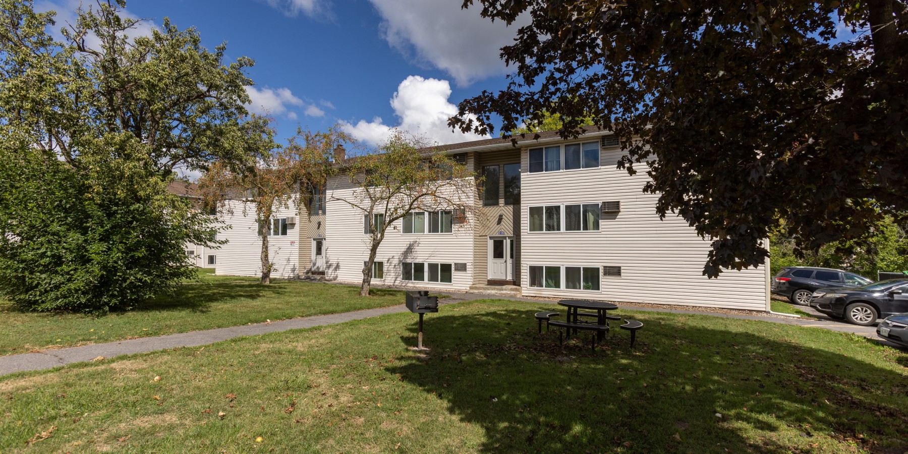 Lawn and picnic area in front of an apartment building at Brook Manor Apartments, Syracuse NY