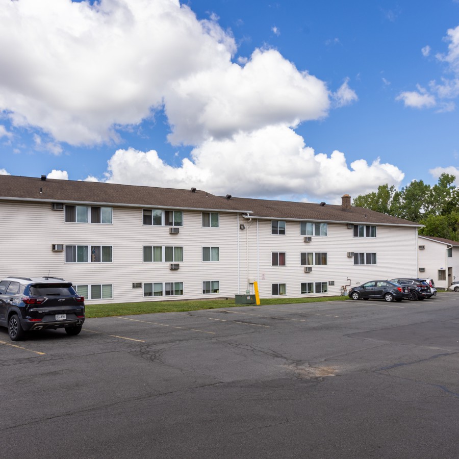 Long three-story apartment building and parking at Brook Manor Apartments, Syracuse NY